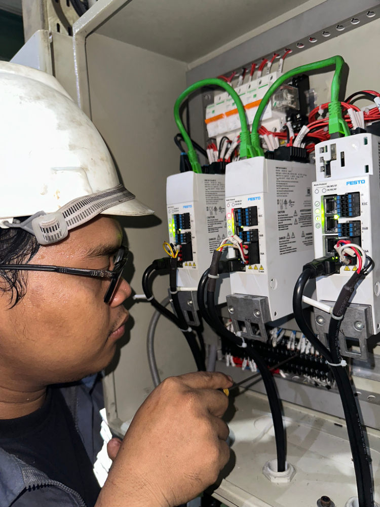 Teknisi MMG merapikan wiring servo drive di panel kontrol
