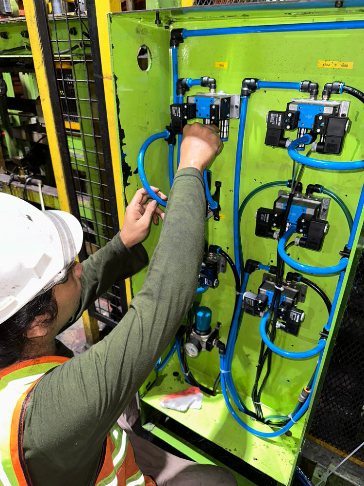 Teknisi MMG memasang panel valve pneumatik